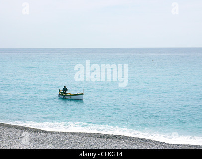 Angeln-Mann allein in einem kleinen weißen Boot auf das klare Mittelmeer vom schönen Wetter in Nizza, Frankreich Stockfoto