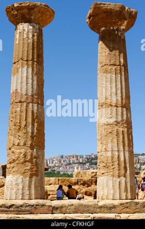 Agrigento. Sizilien. Italien. Blick auf die mittelalterliche Stadt Agrigent durch aufrechte Säulen der Tempel des Herakles oder Tempio di Stockfoto