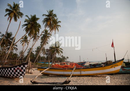 Palmen und Angelboote/Fischerboote auf Colva Beach in Indien Stockfoto