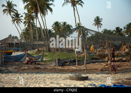 Palmen und Angelboote/Fischerboote auf Colva Beach in Indien Stockfoto