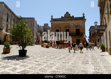 Erice. Sizilien. Italien. Blick auf die großen zentralen Piazza Umberto mit Café-Tischen und ehemaligen Palazzo jetzt als Bank genutzt. Die Stockfoto