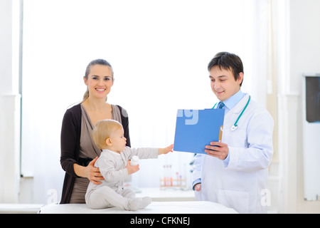 Interessierten Baby wirbt für Patienten-Karte in der Hand der Kinderarzt Stockfoto