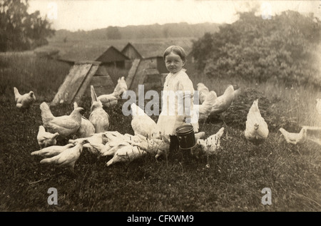 Kleines Mädchen aus einem Eimer Hühner füttern Stockfoto