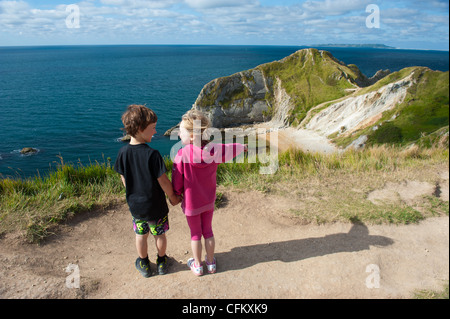 Kinder freuen sich über einen Urlaub bei Durdle Door, West Lulworth, Dorset, UK Stockfoto