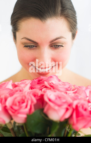 Studio shot der Frau duftende Rosen Stockfoto