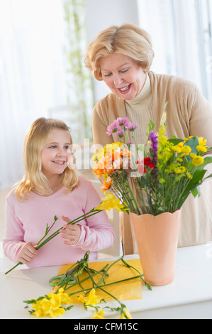 USA, New Jersey, Jersey City, Smiling senior Frau arrangieren von Blumen mit Enkelin (8-9) Stockfoto