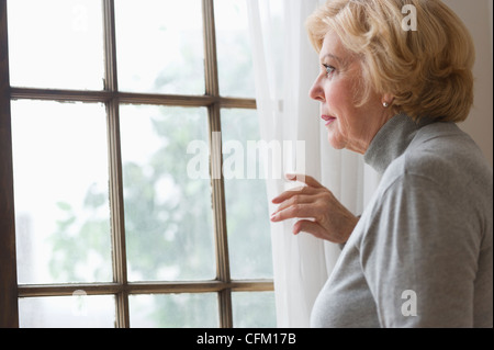 USA, New Jersey, Jersey City, Porträt von senior Frau Blick durch Fenster Stockfoto