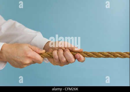 Nahaufnahme eines Mannes Hände ziehen Seil, Studio gedreht Stockfoto