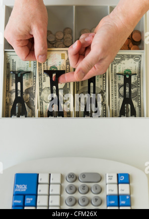 Nahaufnahme von Menschenhand, Banknoten in die Registrierkasse, Studioaufnahme Stockfoto