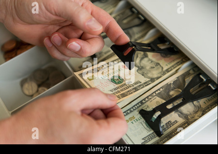 Nahaufnahme von Menschenhand, Banknoten in die Registrierkasse, Studioaufnahme Stockfoto