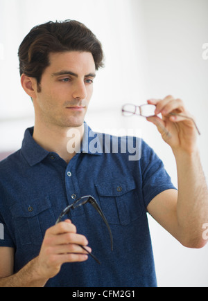 USA, New Jersey, Jersey City, Mann betrachten Brillen im Shop Stockfoto