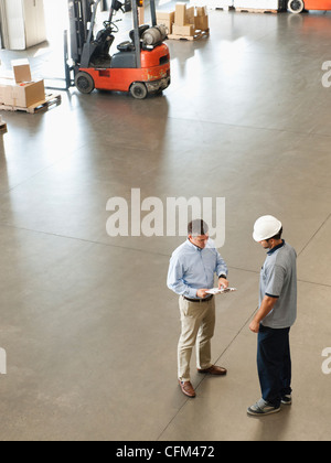 USA, Kalifornien, Santa Ana, Arbeiter im Lager sprechen Stockfoto