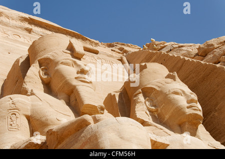 Abu Simbel. Ägypten. Nahaufnahme niedrigen Winkel von zwei der vier sitzende Kolosse an der Fassade des großen Tempels 13. Jh. v. Chr. Stockfoto