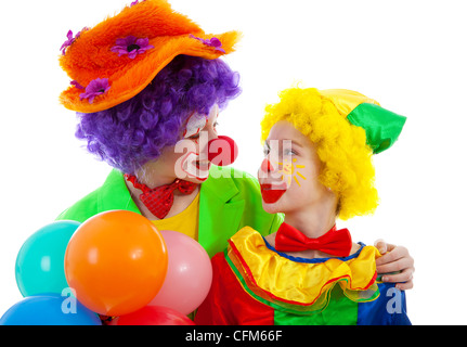 zwei Kinder gekleidet als bunte lustige Clown mit Luftballons auf weißem Hintergrund Stockfoto