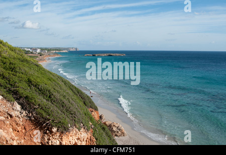 Mit Blick auf das klare blaue Wasser von binigaus Strand von den Klippen in der Nähe von Sant Tomas resort Menorca Spanien Stockfoto