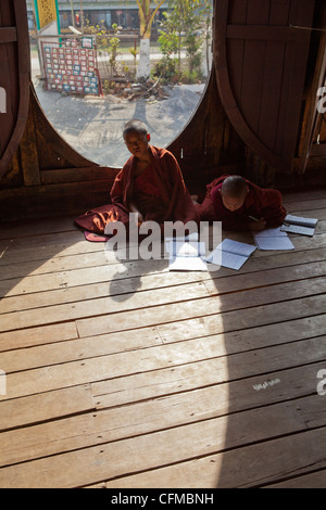 Die einzigartige ovale Fenster in diesem alten Teakholz Kloster in Shwenyaung, in der Nähe von Lake Inle dient als eine Schule für jungen Novizen. Stockfoto