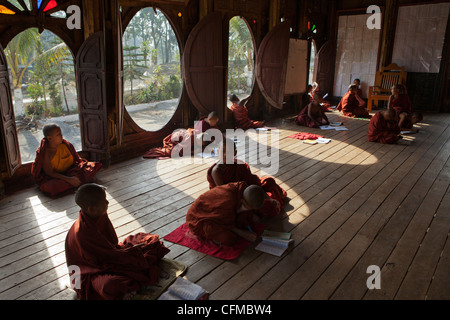 Die einzigartige ovale Fenster in diesem alten Teakholz Kloster in Shwenyaung, in der Nähe von Lake Inle dient als eine Schule für jungen Novizen. Stockfoto