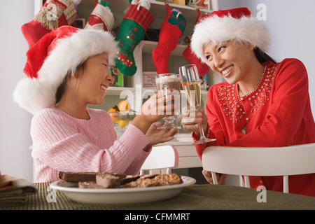 USA, California, Los Angeles, Mutter und Tochter in Santa hüten Toasten mit Getränken Stockfoto