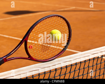 Tennisschläger im Netz in der Mitte des Tennisplatzes Stockfoto
