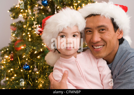 Porträt von Vater und Tochter am Weihnachtsbaum, Los Angeles, California, USA Stockfoto
