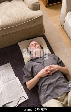 USA, California, Los Angeles, Porträt des Mannes mit Kopfhörern am Boden liegend Stockfoto