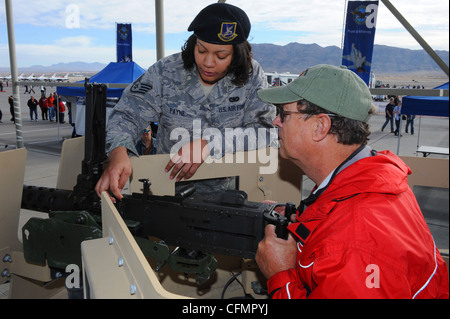 U.S. Air Force Staff Sgt. Alverdite Payne, 99. Sicherheitskräfte-Geschwader, demonstriert, wie man die 50. Kaliber Maschinengewehr montiert auf einem Humvee zu Rick Fey während der 2011 Aviation Nation Open House Nov. 12, auf Nellis Air Force Base, Nev. Aviation Nation feiert 70 Jahre Luftkraft in Las Vegas und die Leistungen der Luftwaffe in Luft, Raum und Cyberspace. Stockfoto