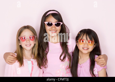 Studio-Porträt von drei Teenager (16-17) Mädchen mit Sonnenbrille Stockfoto