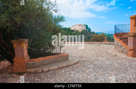 Blick auf ein Kloster in der Nähe von Fuensanta, Murcia, Spanien. Gepflasterte Straße, blauen Himmel und Oliven Baum. Stockfoto