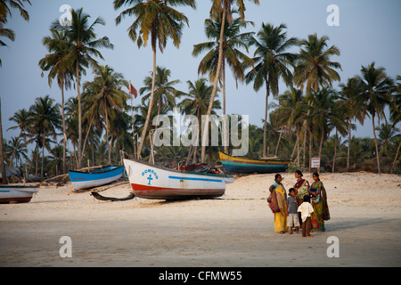 Palmen und Angelboote/Fischerboote auf Colva Beach in Indien Stockfoto