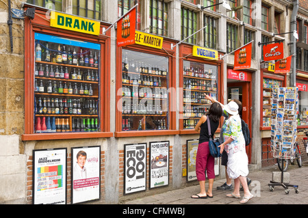 Horizontale Nahaufnahme von Touristen auf der Suche auf ein riesiges Display belgisches Bier in einem Schaufenster in Belgien. Stockfoto