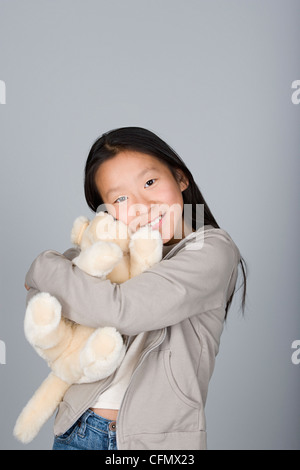 Studio-Porträt des chinesischen Mädchens (16-17) umarmt Teddybär Stockfoto