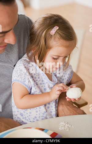 USA, California, Los Angeles, Mädchen auf Vaters Schoß peeling Ei Stockfoto