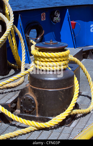 Gelbes marine Seil umwickelt ein Capstan auf einer Fähre. Stockfoto