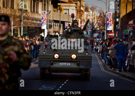 Truppen in gepanzerten Fahrzeugen vorbeifahren High Street Läden während einer königlichen Yeomanry Parade beobachten Zuschauer vom Gehsteig Stockfoto