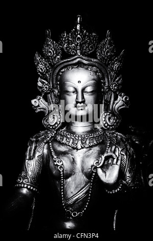 Grüne Tara-Statue. Buddhistische Gottheit Statue auf schwarzem Hintergrund. Monochrom Stockfoto