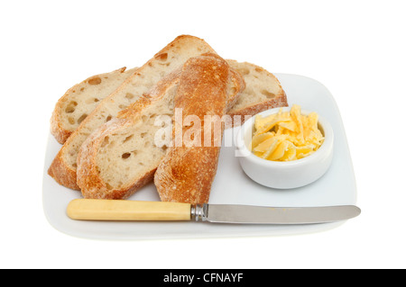 Scheiben Bauernbrot auf einem Teller mit Butter und ein Messer isoliert gegen weiß Stockfoto