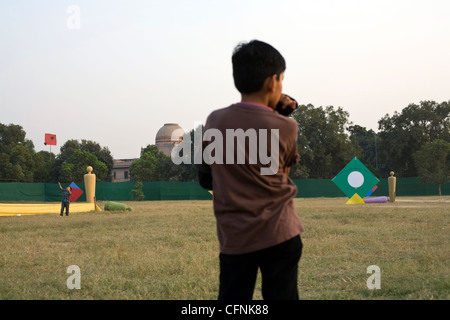 Ein Junge beobachtet andere Kinder Drachen fliegen während einer Drachenfliegen Festival am India Gate, Neu-Delhi Indien Stockfoto