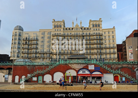 Spielen Sie Beach-Volleyball auf Brighton Seafront mit dem Grand Hotel hinter UK Stockfoto