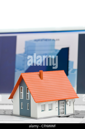 Musterhaus vor Computer mit Finanzierungsplan - Verpfändung oder Hause Finanzierung Konzept Stockfoto