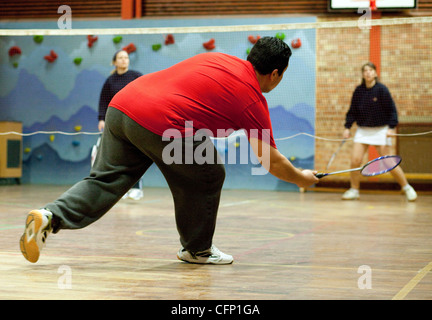 Body Diversity UK im Sport; ein übergewichtiger Mann spielt Badminton in einem lokalen Club in Großbritannien Stockfoto