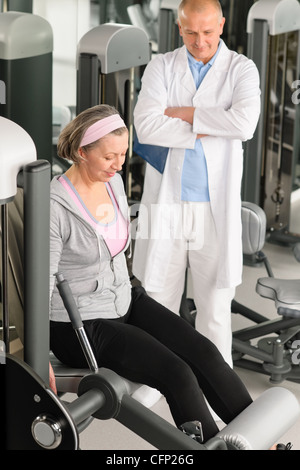 Physiotherapeut männlich unterstützen aktive senior Frau Training im Fitness-Studio Stockfoto