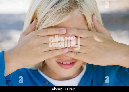 Junge Abdeckung Augen mit Händen Stockfoto