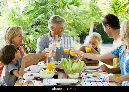 Mehr-Generationen-Familie Toasten mit Orangensaft im Freien, Porträt Stockfoto