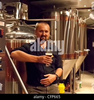 Mann hält Bier in "Aegir Bryggeri" Mikrobrauerei in Flam, Aurland, Norwegen Stockfoto