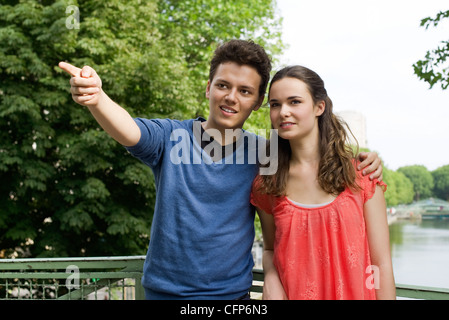 Junges Paar im Freien, junge Mann zeigte in Ferne, Porträt Stockfoto