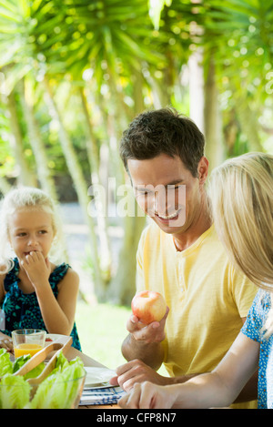 Familie mit Mahlzeit im Freien, ein Mann im Mittelpunkt Stockfoto