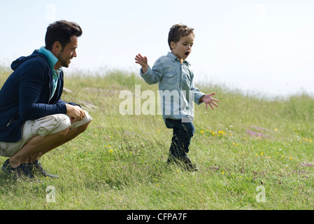 Vater und Sohn spielen in Wiese Stockfoto