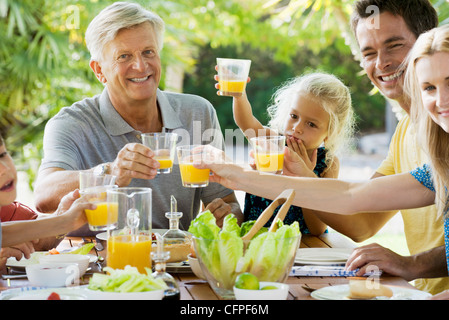 Mehr-Generationen-Familie Toasten mit Orangensaft im Freien, Porträt Stockfoto