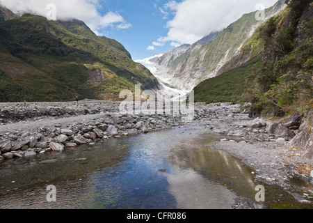 Franz Josef Glacier, West Coast, New Zealand, spiegelt sich in einem Bach im Tal. Stockfoto