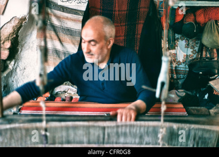 IRAN, ISFAHAN: Iranische handwerklich traditionellen Material mit einem Muster und ein hölzerner Webstuhl weben.  Archiv Foto von 1977. Stockfoto